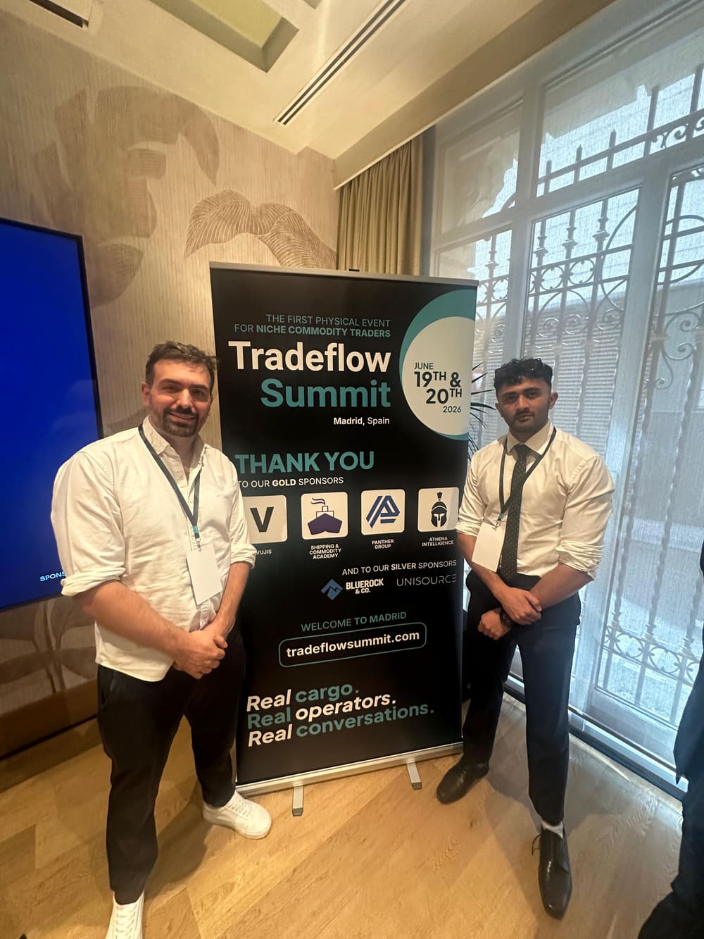 Damien Würsten and the Vujis team in front of the Tradeflow Summit Madrid gold sponsors banner